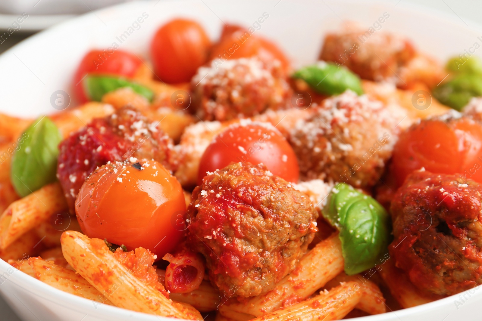 Photo of Delicious pasta with meatballs and tomato sauce on plate, closeup