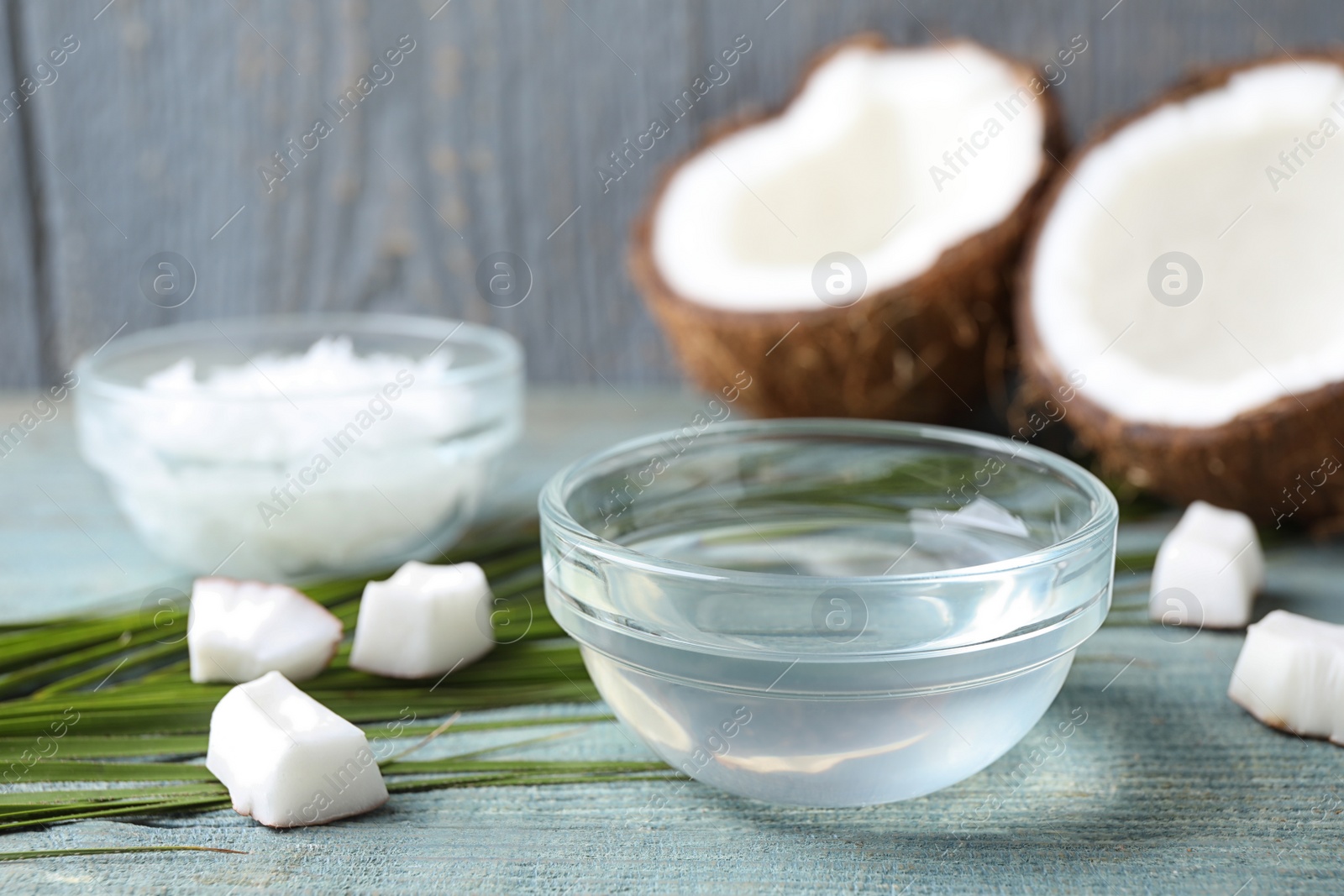 Photo of Coconut oil on light blue wooden table, space for text