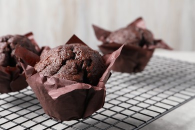 Photo of Tasty chocolate muffins on grey table, closeup. Space for text