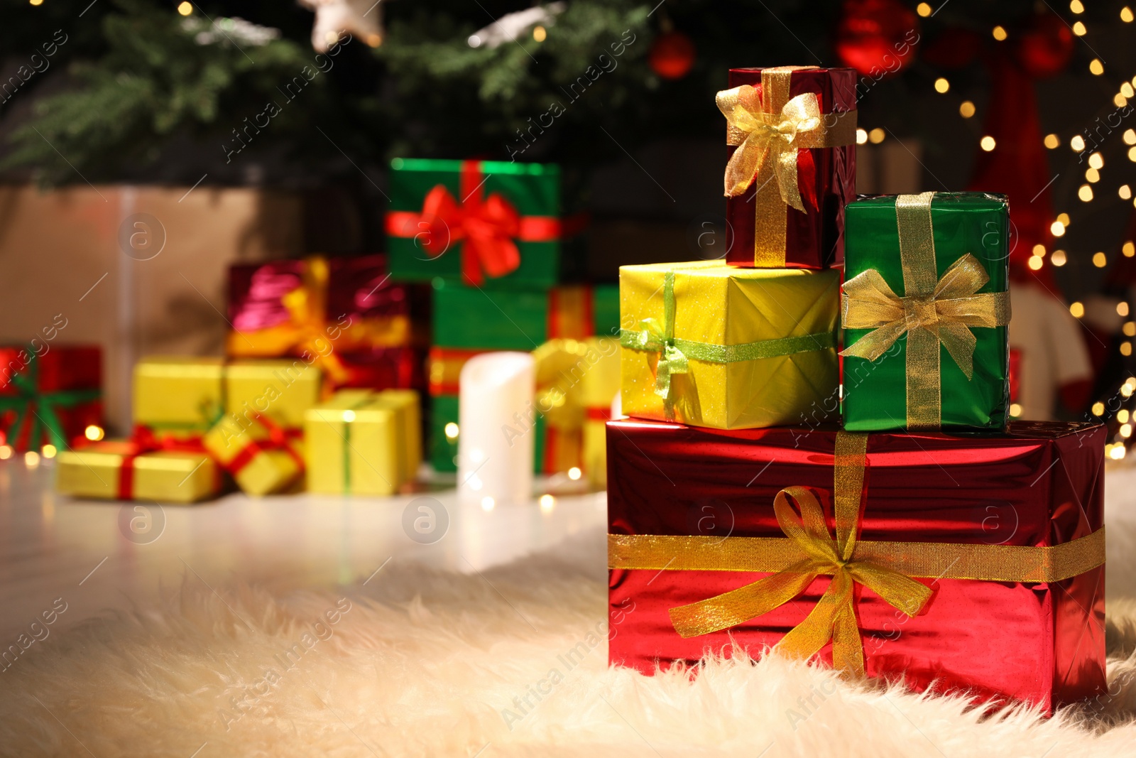 Photo of Beautiful gift boxes near Christmas tree in room, space for text