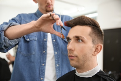 Professional barber working with client in hairdressing salon. Hipster fashion