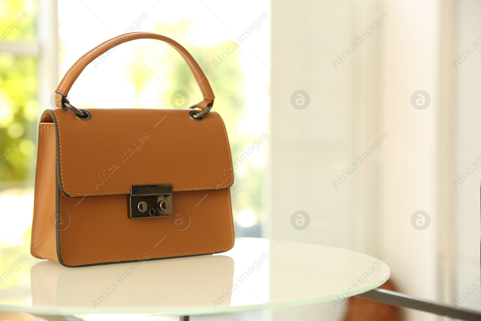 Photo of Stylish woman's bag on stand in boutique. Space for text