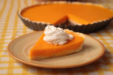 Photo of Piece of fresh homemade pumpkin pie with whipped cream on table