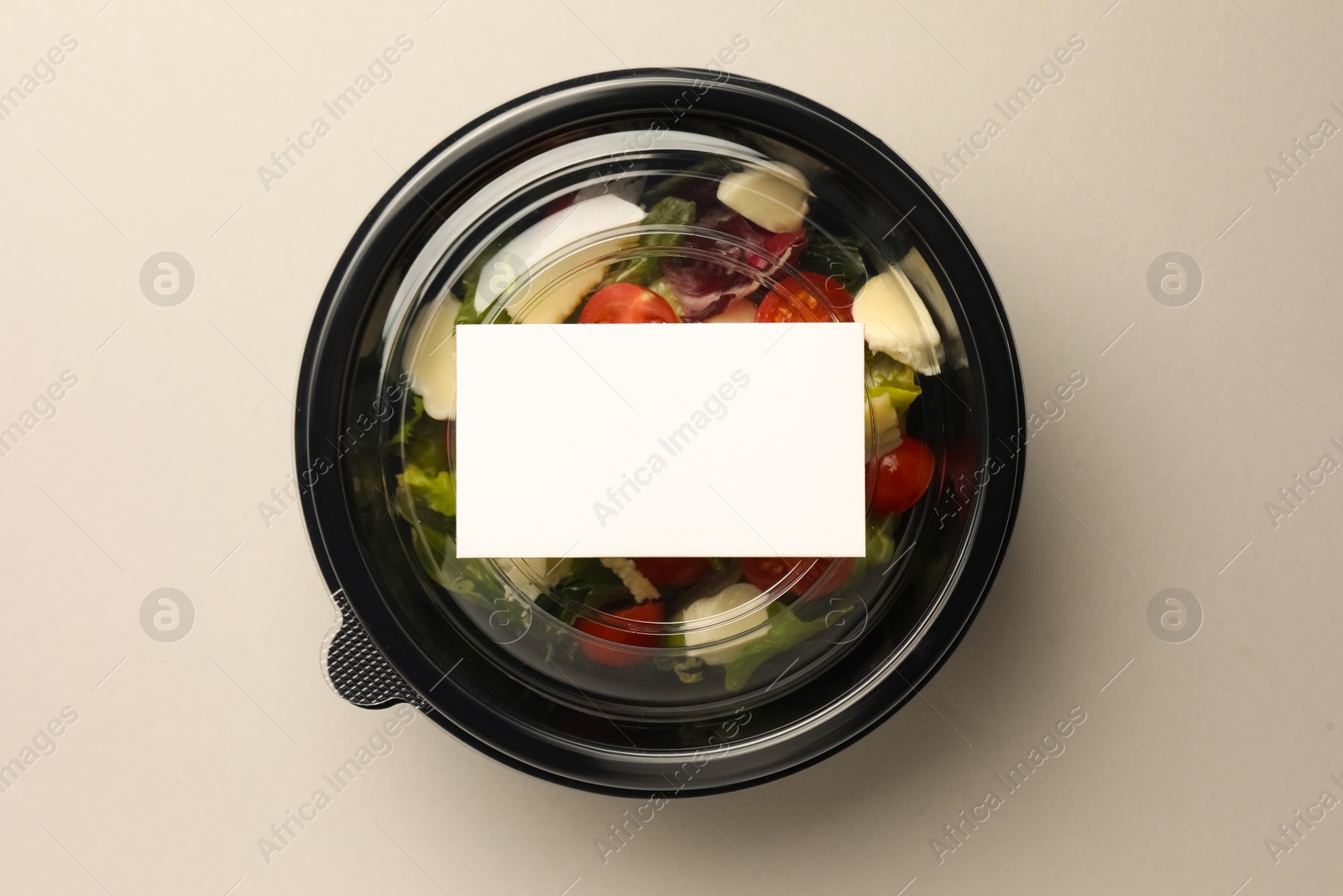 Photo of Tasty food in container on light background, top view. Space for text