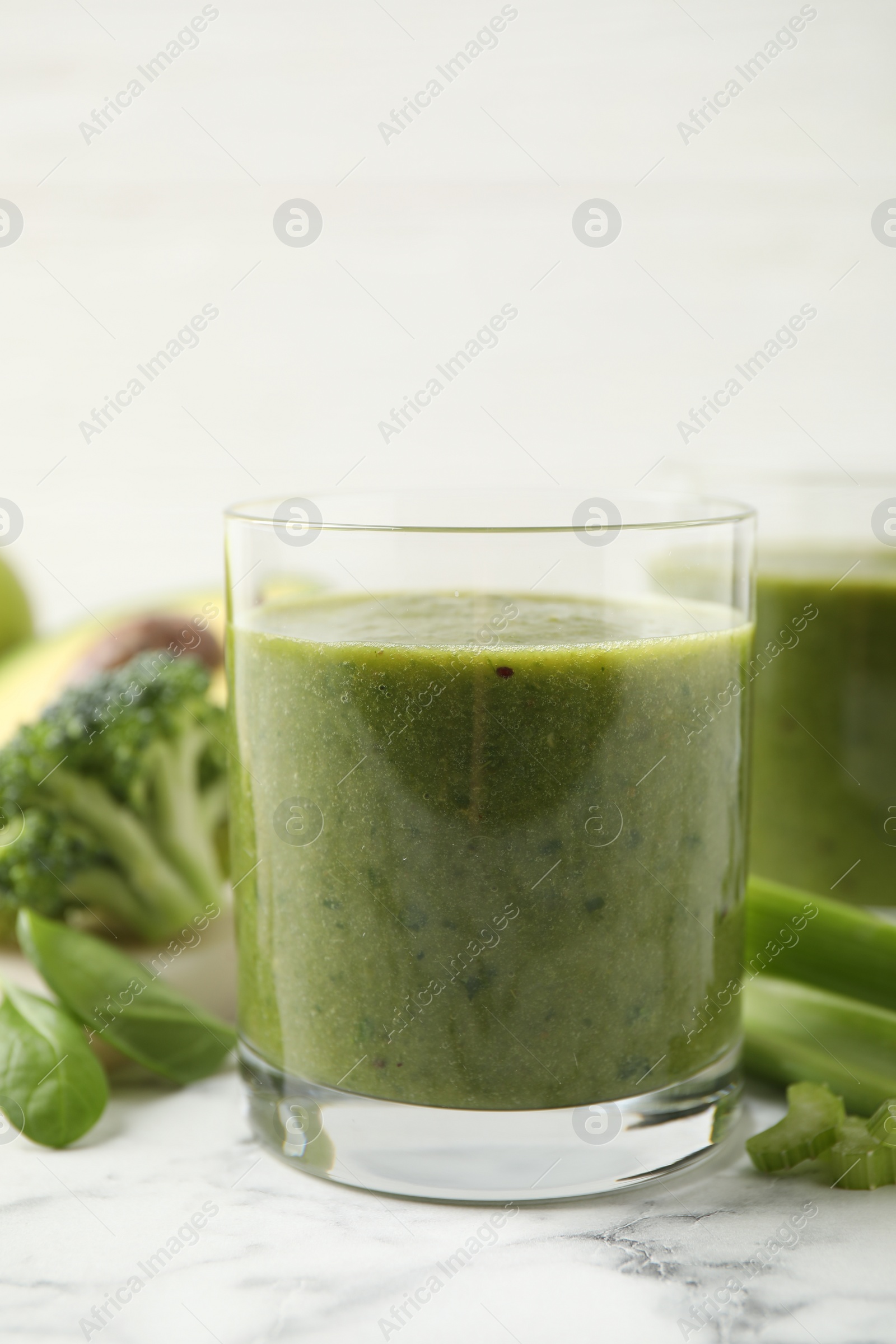 Photo of Delicious fresh green juice on white marble table, closeup