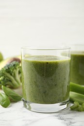 Photo of Delicious fresh green juice on white marble table, closeup