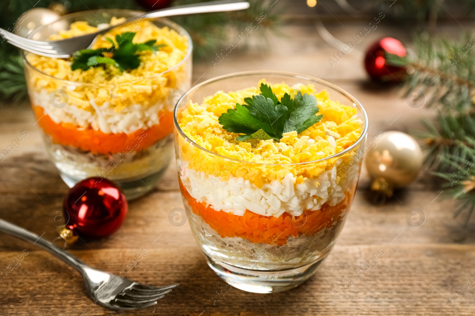 Photo of Traditional russian salad Mimosa served on wooden table