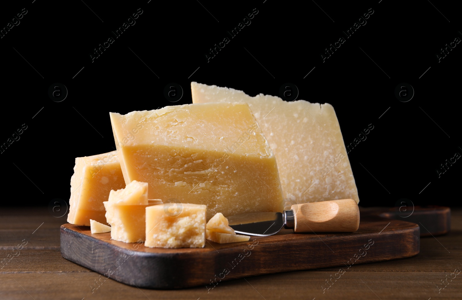 Photo of Delicious parmesan cheese with knife on wooden table