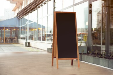 Photo of Empty A-board near building outdoors. Mockup for design