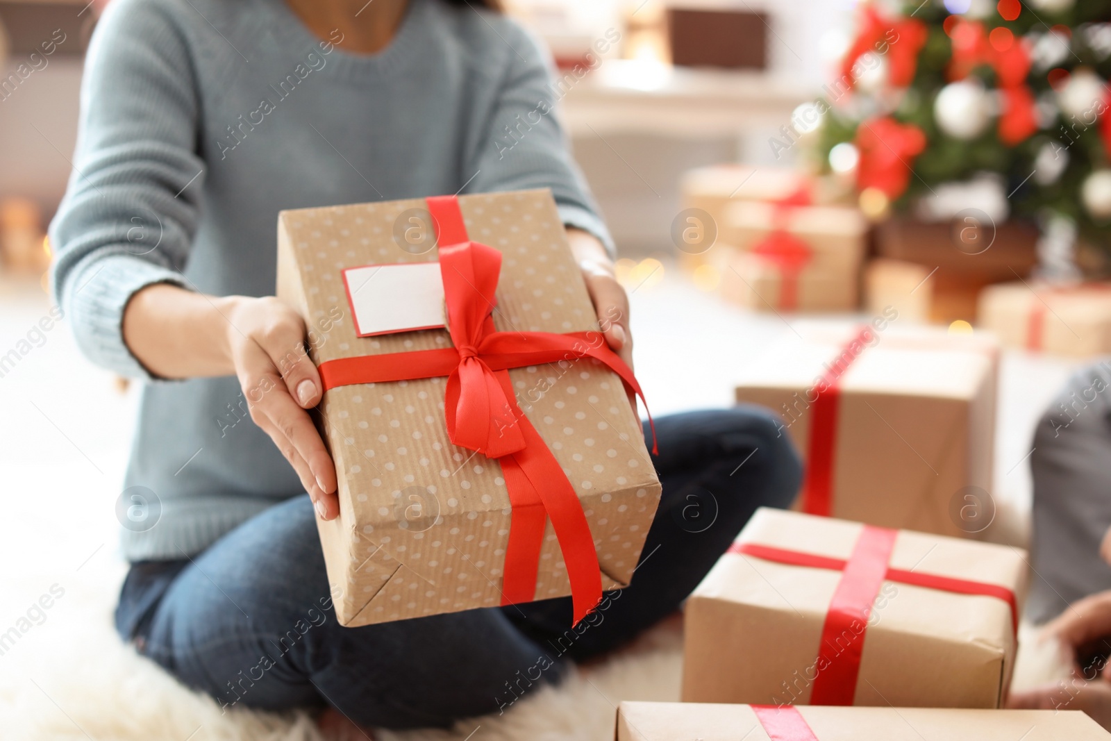 Photo of Young woman with Christmas gift at home