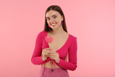 Photo of Pink look. Beautiful woman with lollipop on color background