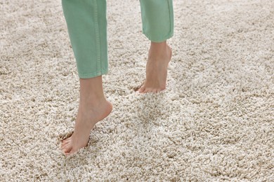 Woman walking on soft light brown carpet at home, closeup