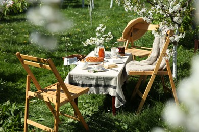 Beautiful table setting with spring flowers in garden on sunny day