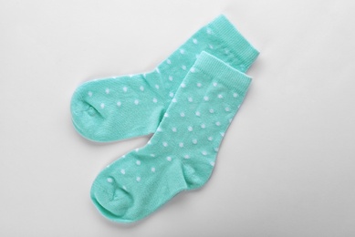 Photo of Cute child socks on white background, top view