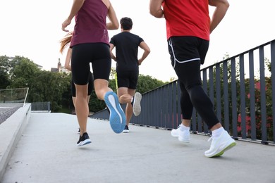 Group of people running outdoors, back view