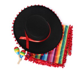 Mexican sombrero hat, maracas and colorful poncho isolated on white, top view
