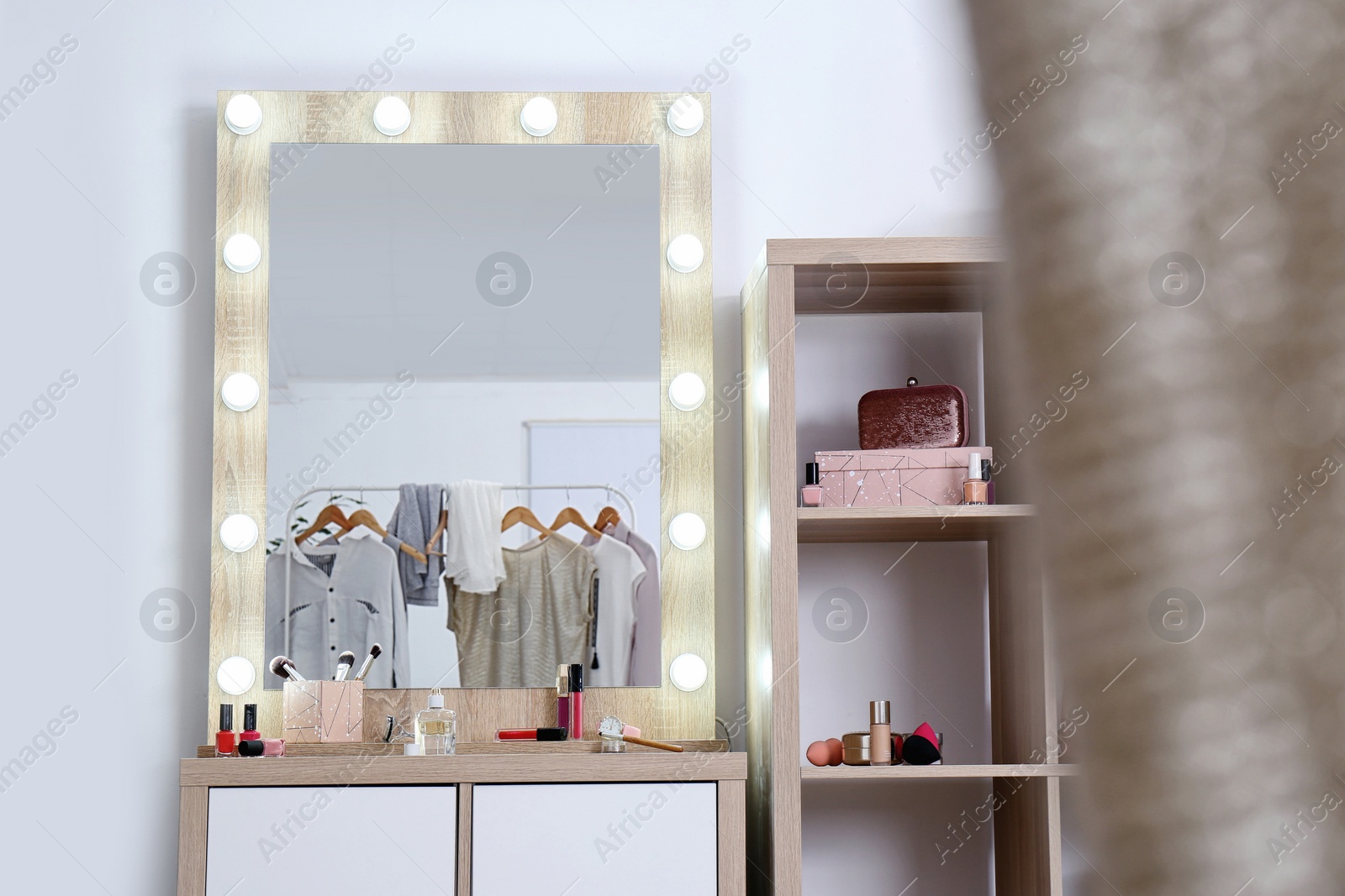 Photo of Dressing room interior with makeup mirror, table and shelving unit