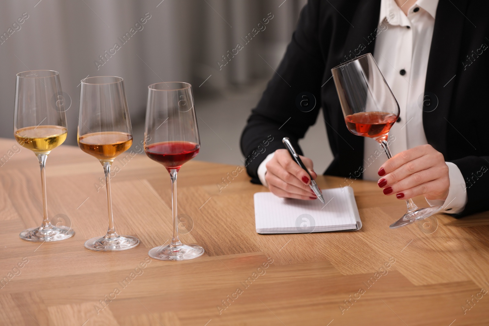 Photo of Sommelier tasting different sorts of wine at table indoors, closeup