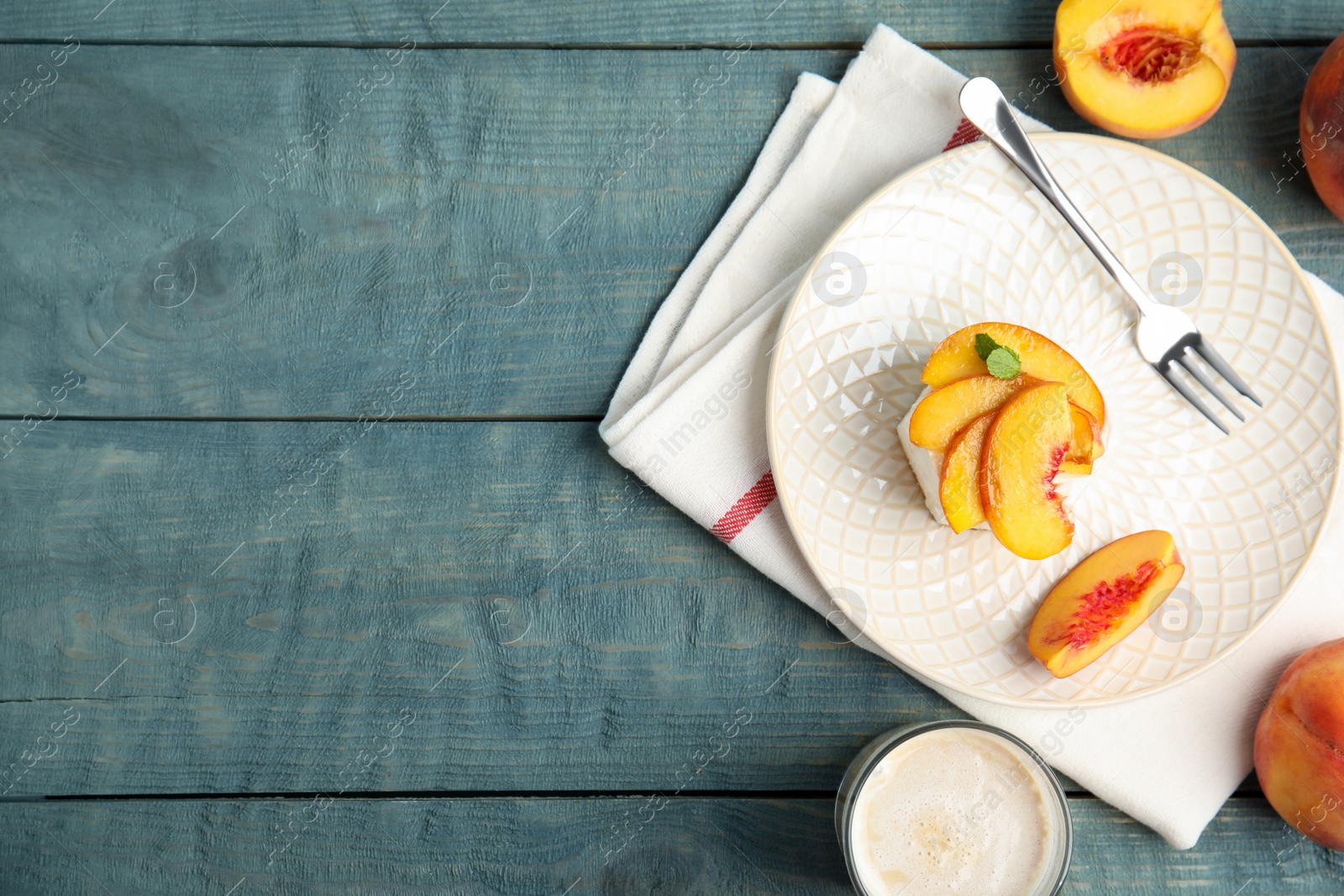 Photo of Delicious peach dessert on blue wooden table, flat lay. Space for text