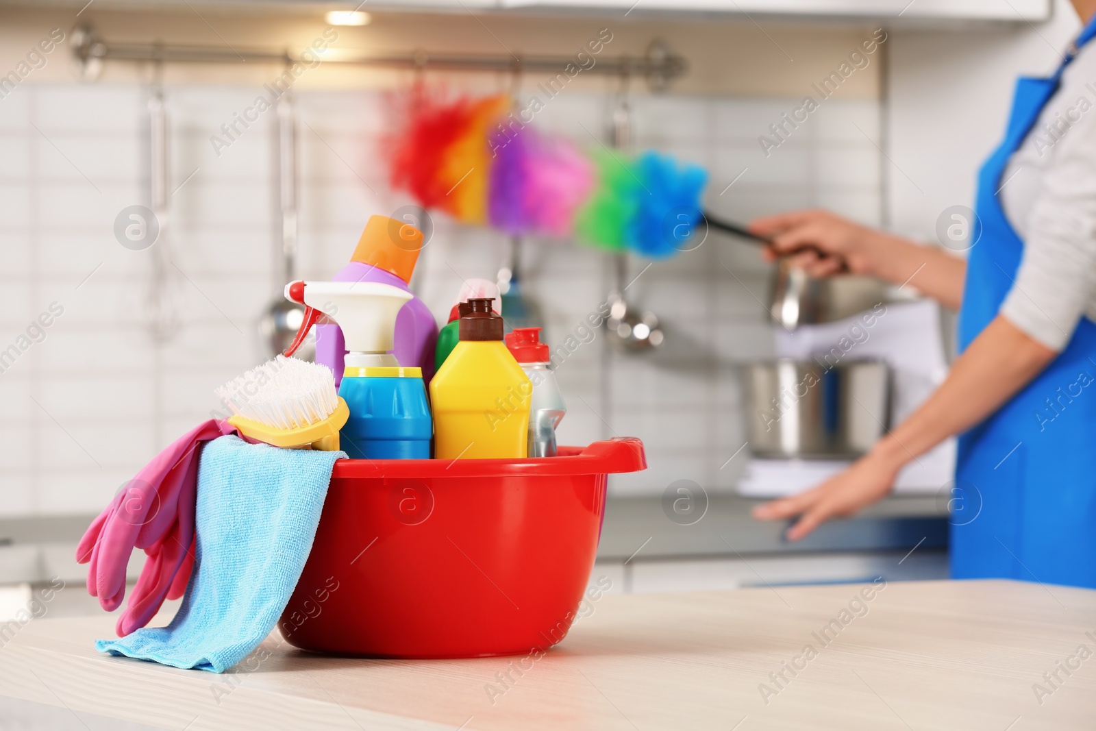 Photo of Set of cleaning supplies on table in kitchen. Space for text