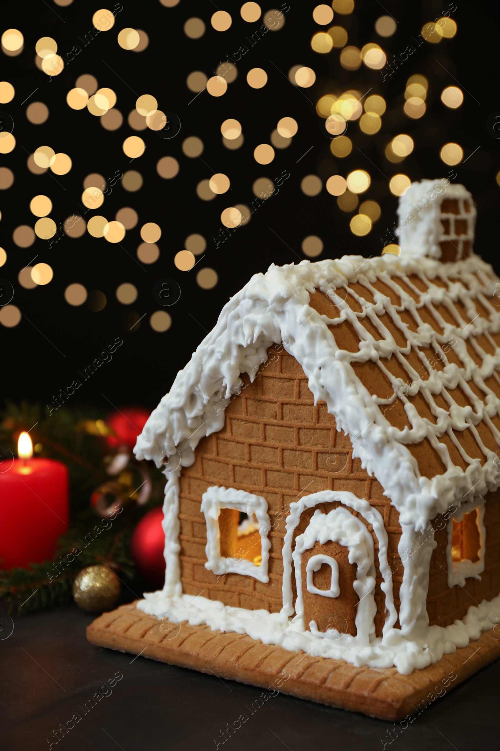 Photo of Beautiful gingerbread house decorated with icing on black table