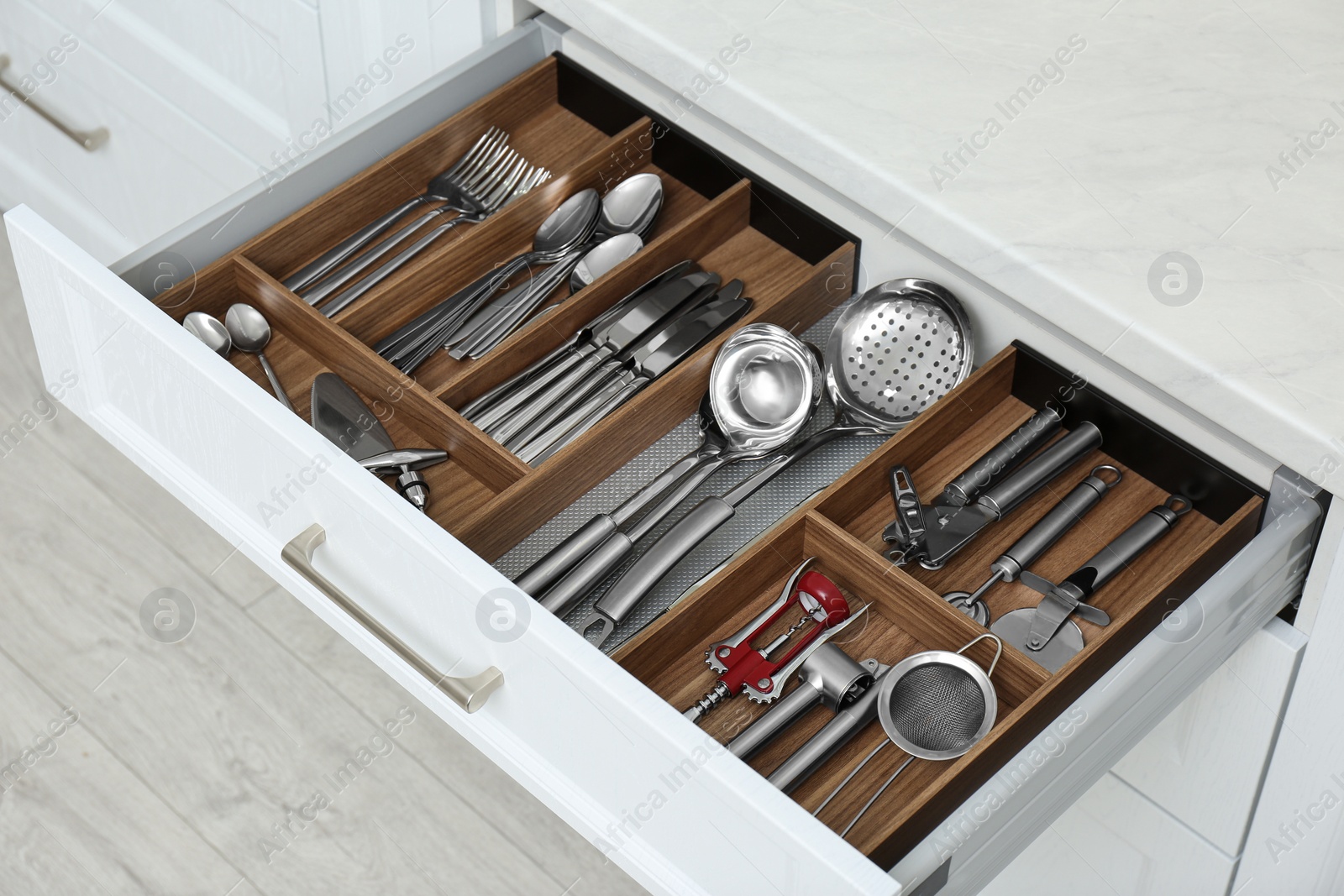 Photo of Open drawer with different utensils and cutlery in kitchen, above view