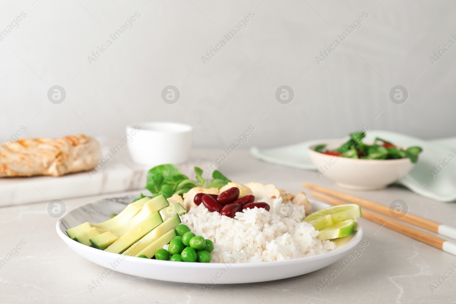 Photo of Plate of boiled rice with vegetables and meat on table