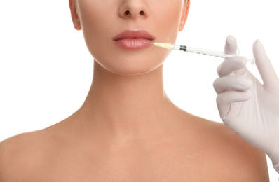 Woman getting lip injection on white background, closeup