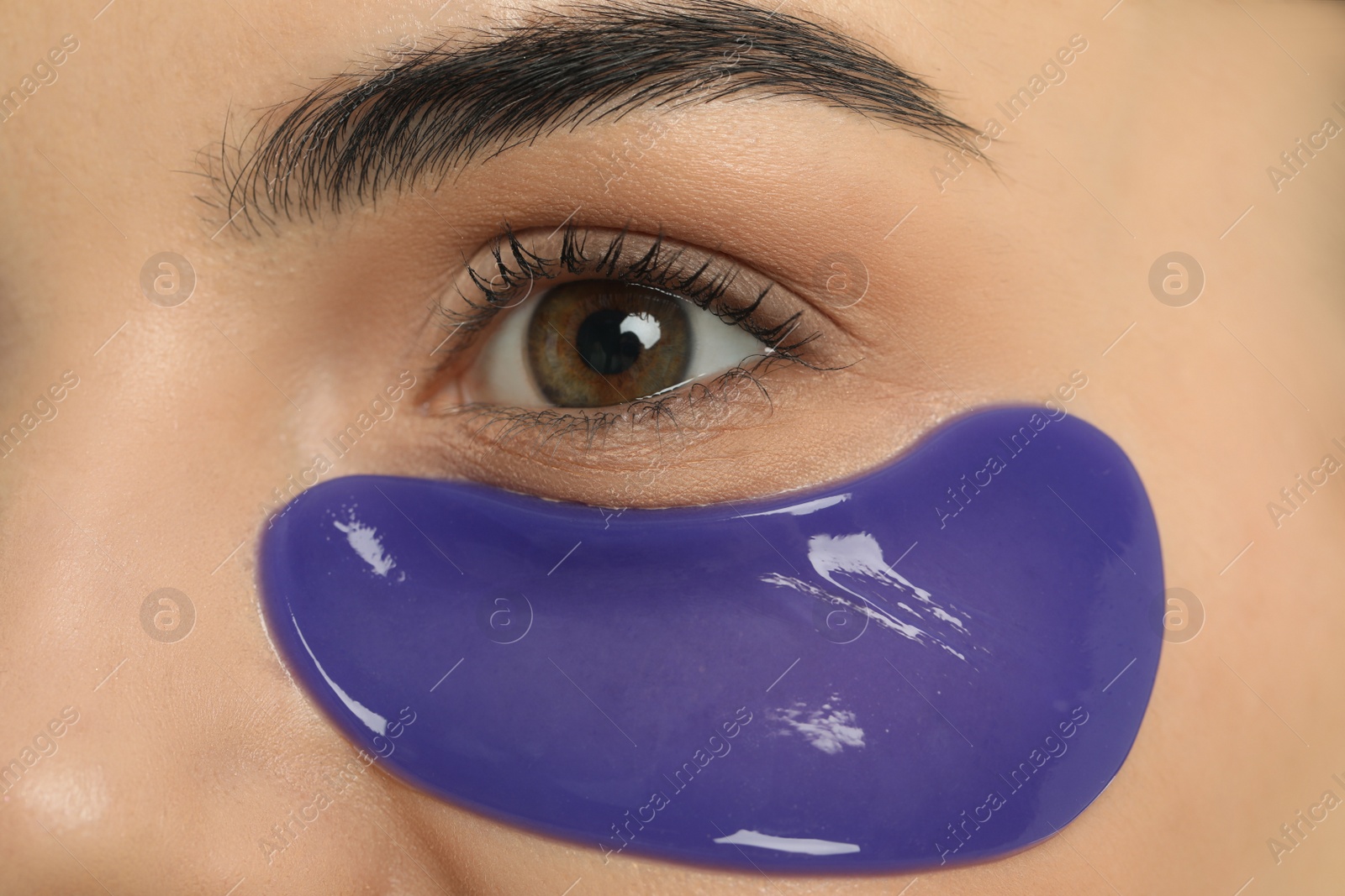 Photo of Young woman with blue under eye patch, closeup