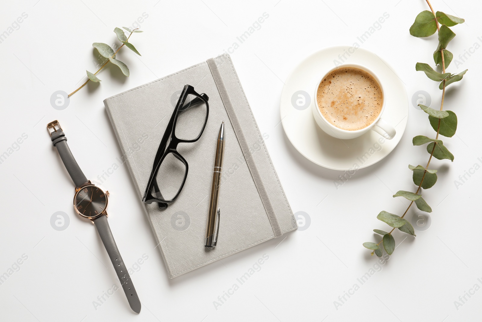 Photo of Flat lay composition with notebook, cup of coffee and wristwatch on white background