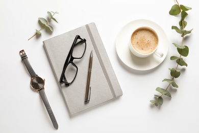 Photo of Flat lay composition with notebook, cup of coffee and wristwatch on white background