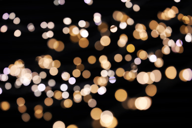 Photo of Golden and white blurred lights on black background. Bokeh effect