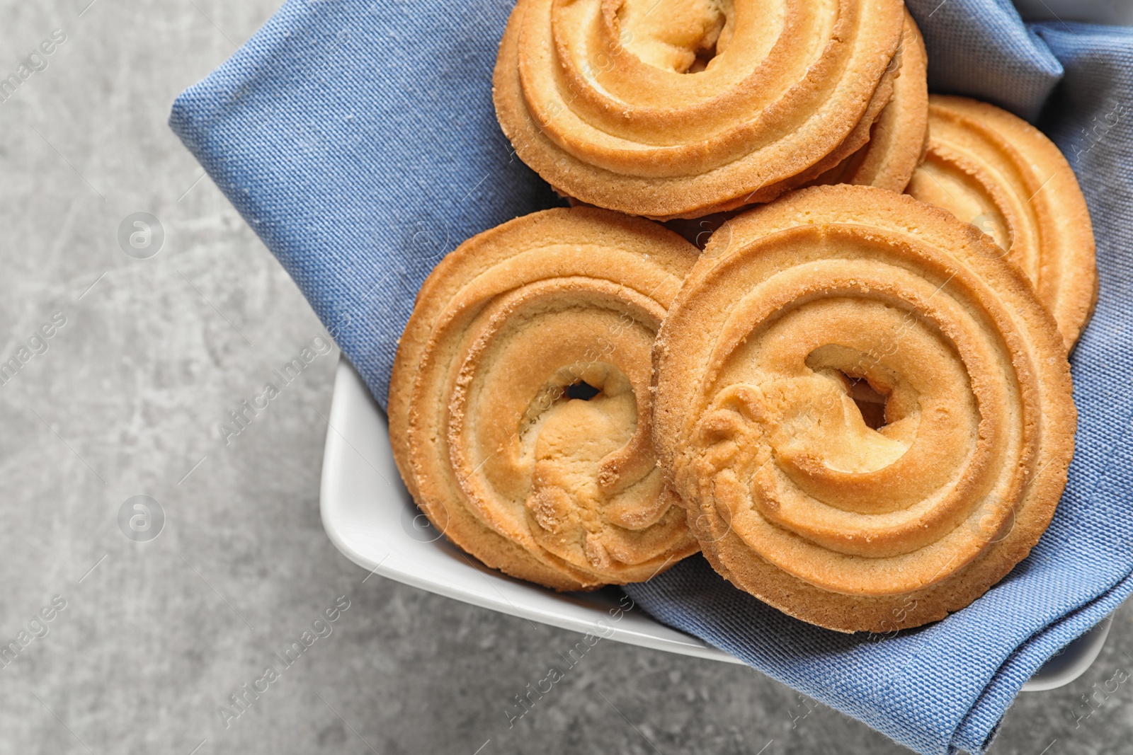 Photo of Bowl with Danish butter cookies on grey table, top view