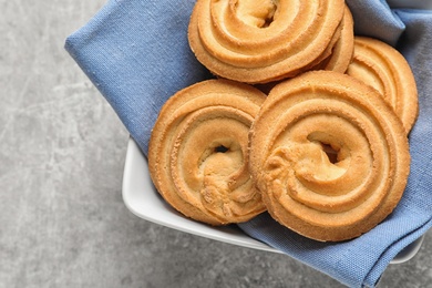 Bowl with Danish butter cookies on grey table, top view