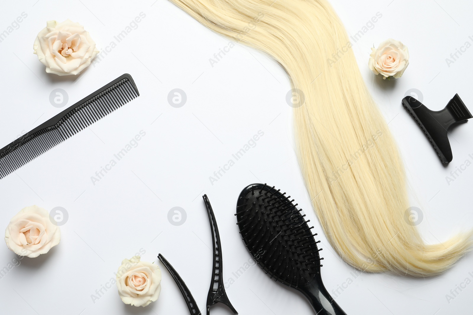 Photo of Flat lay composition with different hairdresser tools and flowers on white background, space for text