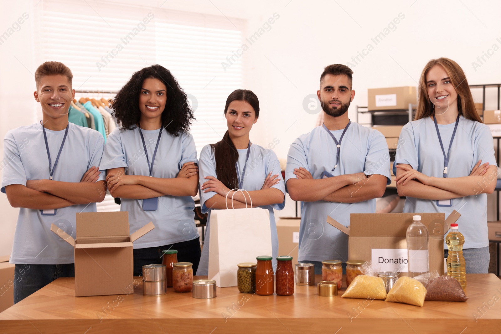 Photo of Portrait of volunteers and food products at table in warehouse