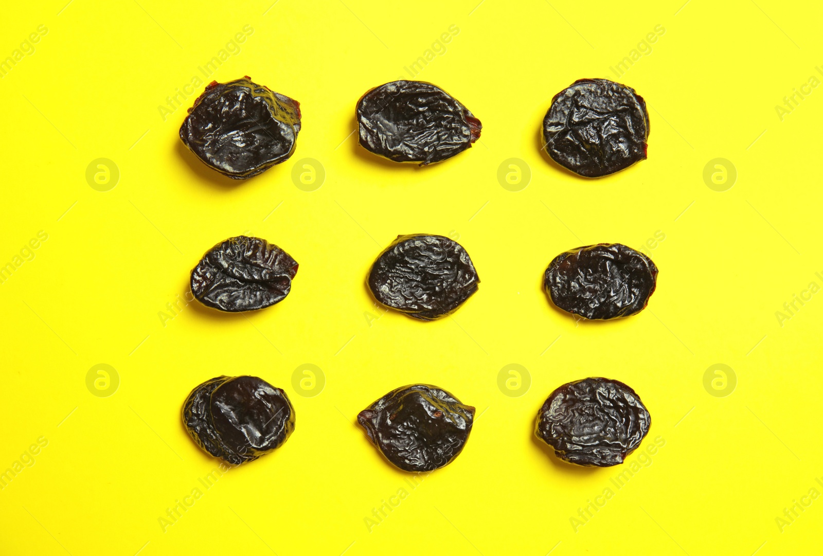 Photo of Flat lay of dried plums on color background. Healthy fruit