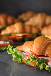 Tasty croissant sandwiches on grey table, closeup