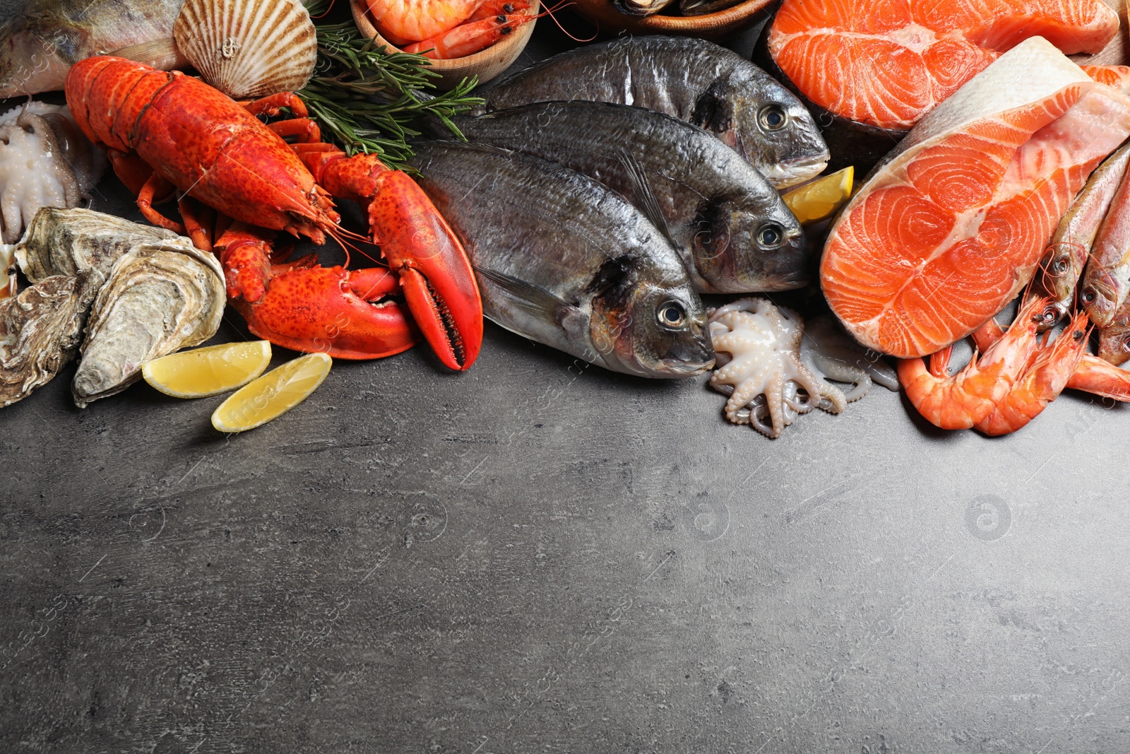 Photo of Fresh fish and different seafood on grey table, flat lay. Space for text