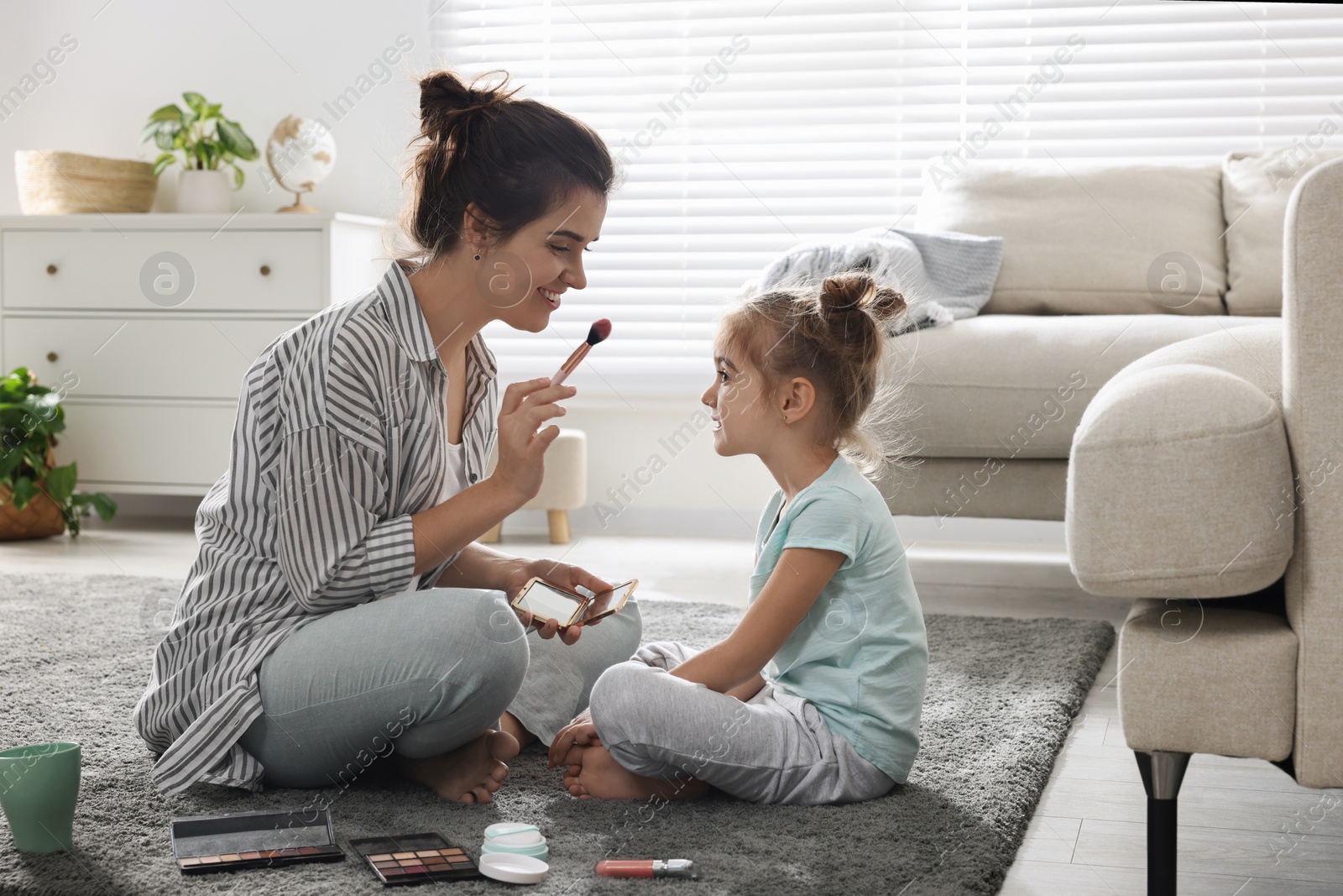 Photo of Young mother and her daughter spending time together at home