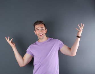 Handsome emotional young man on color background