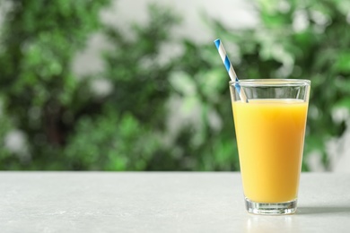 Photo of Glass of orange juice on light table. Space for text