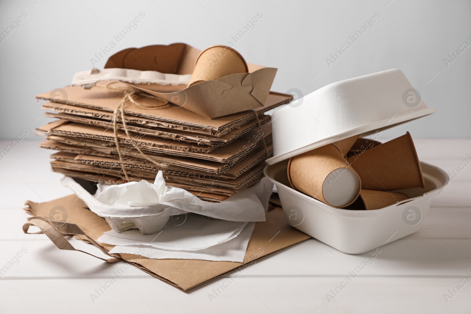 Photo of Heap of waste paper on white wooden table