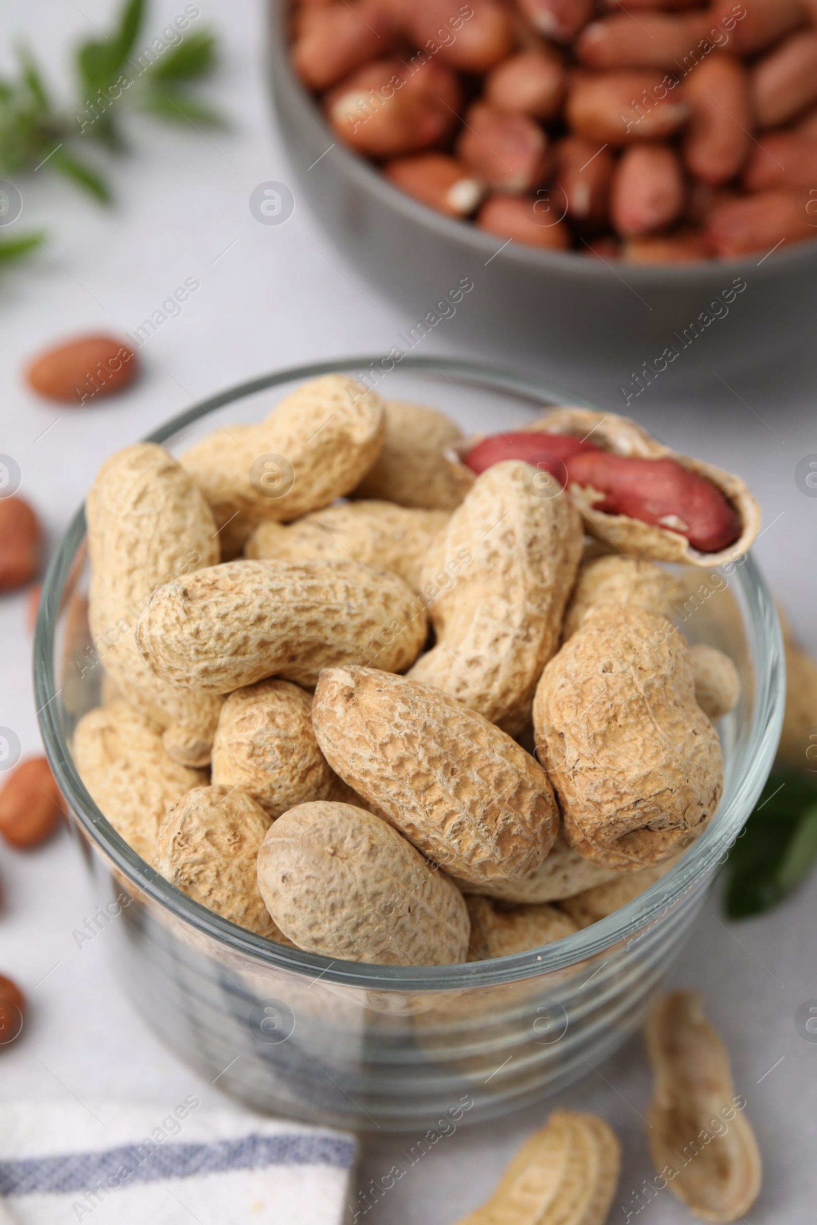 Photo of Fresh unpeeled peanuts on grey table, closeup