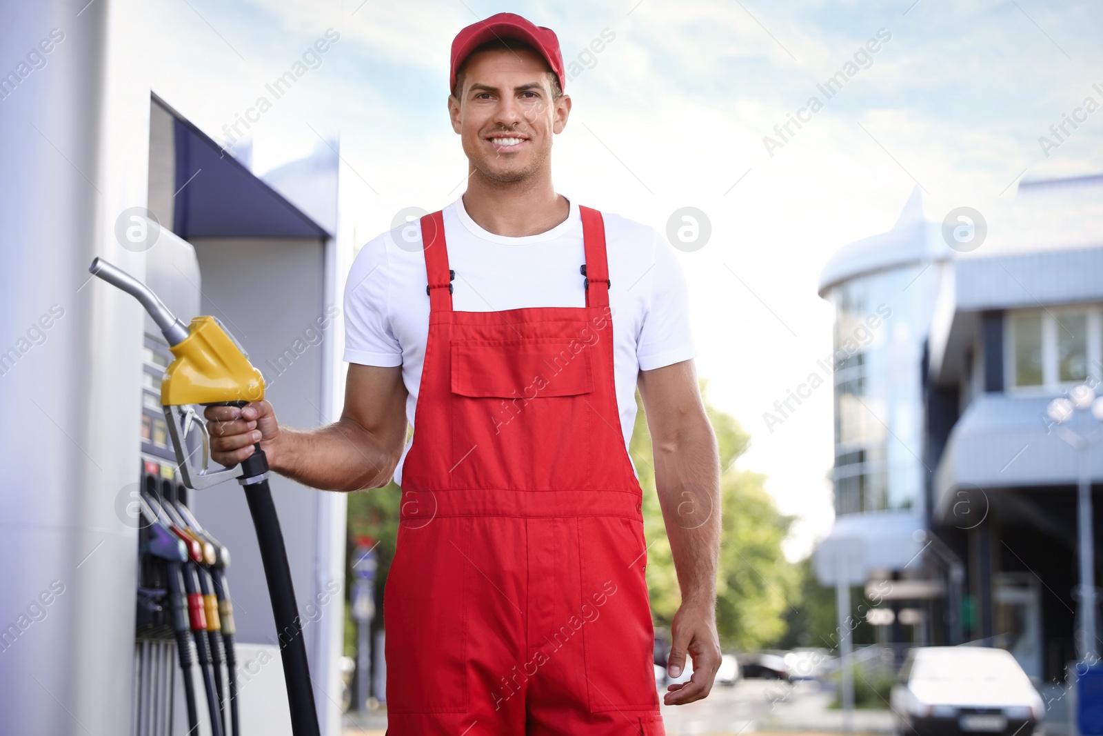 Photo of Worker with fuel pump nozzle at modern gas station