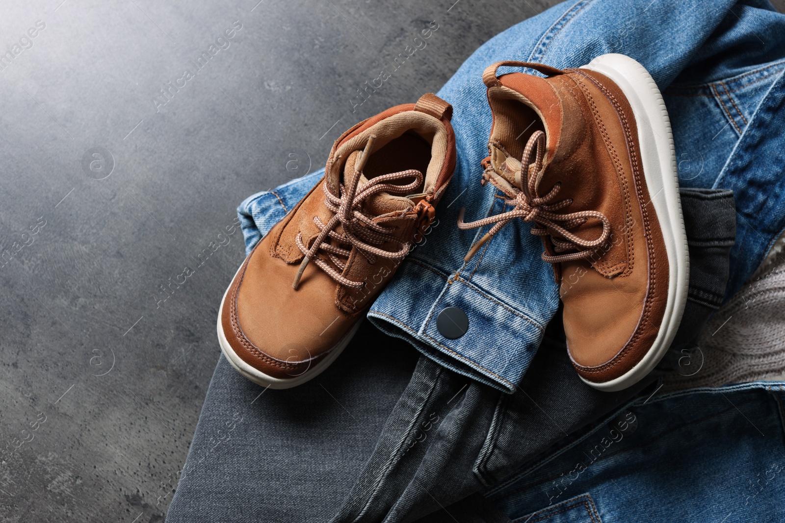 Photo of Warm child clothes and shoes on grey background, flat lay