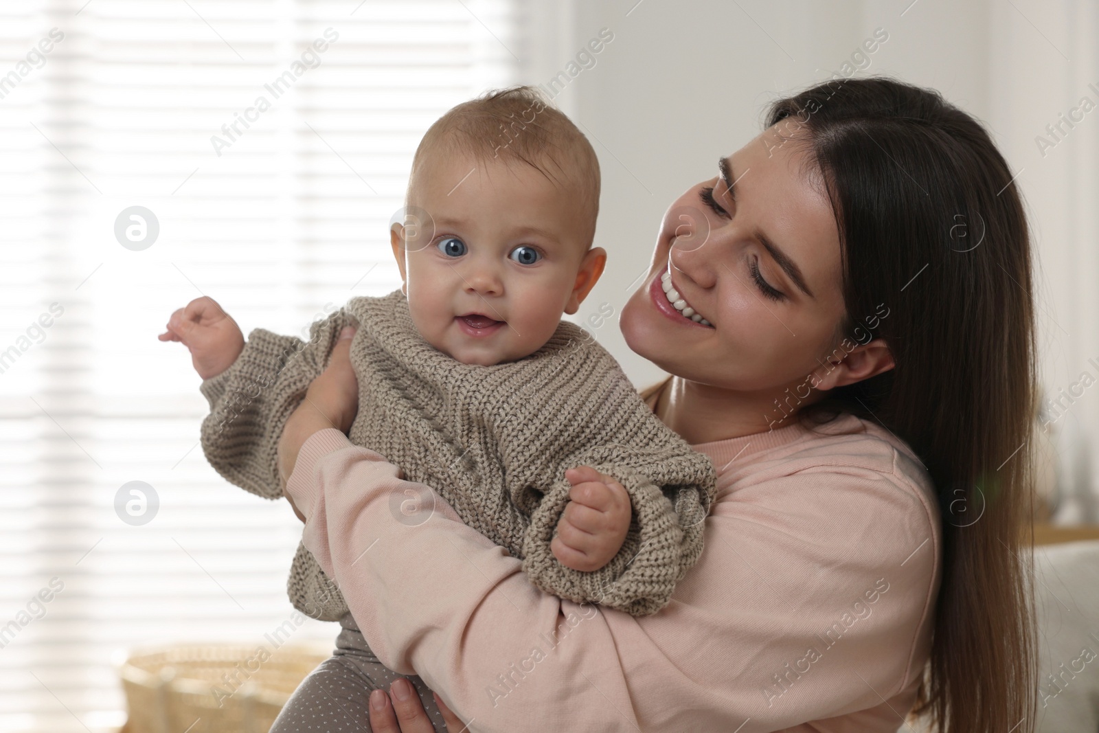 Photo of Happy young mother with her baby at home