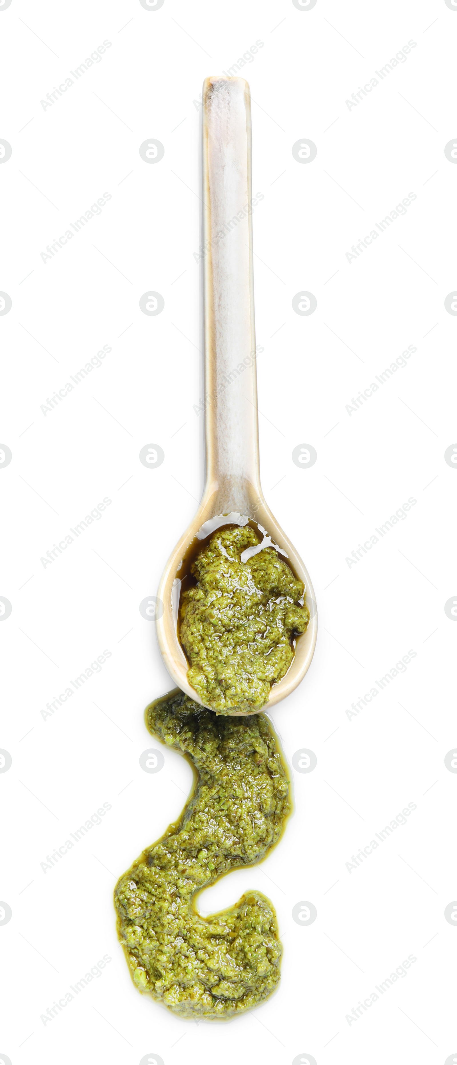 Photo of Sample of tasty pesto sauce and spoon isolated on white, top view