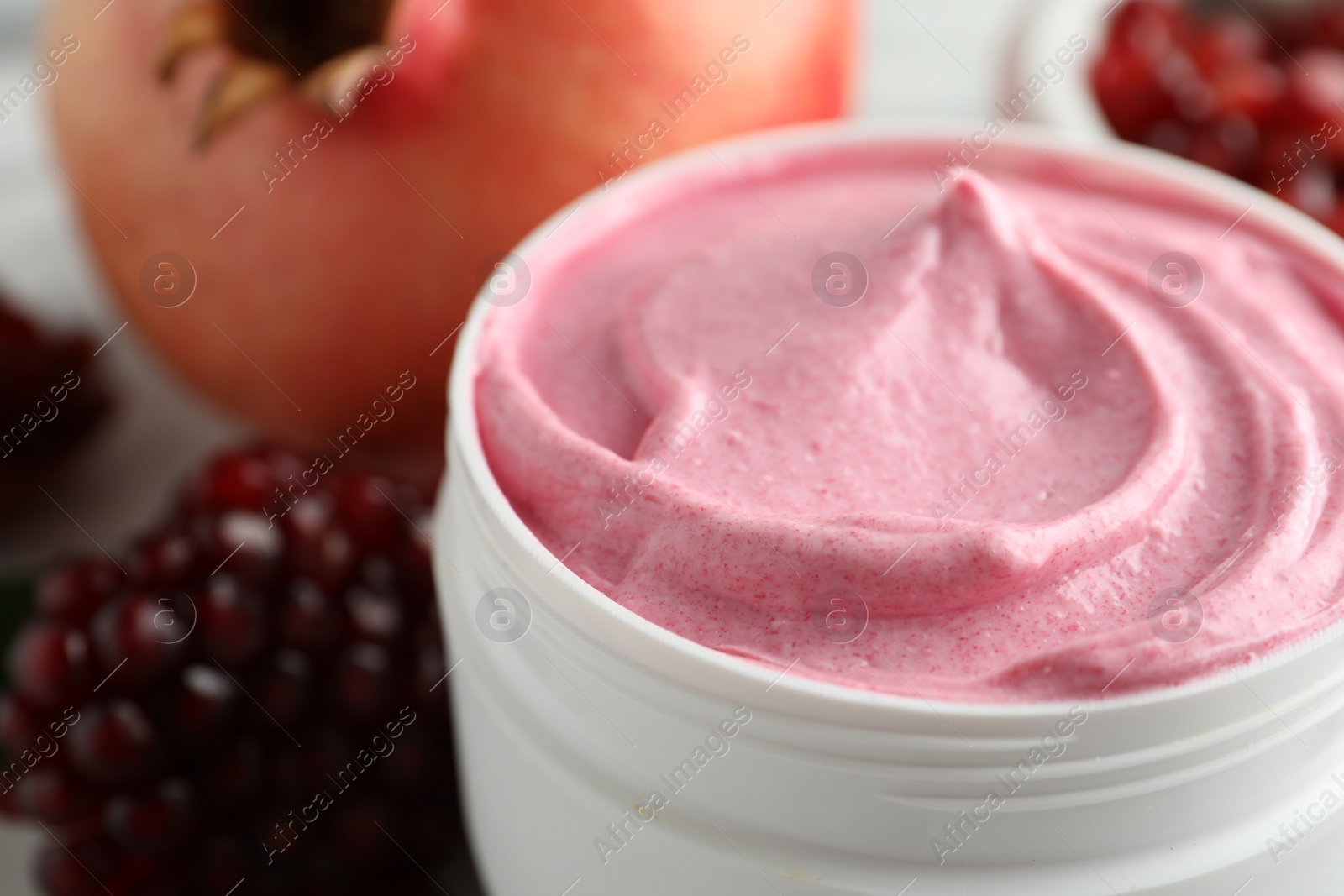 Photo of Jar of facial mask and fresh pomegranate, closeup. Natural organic cosmetics