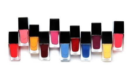 Photo of Bottles of nail polish on white background, top view
